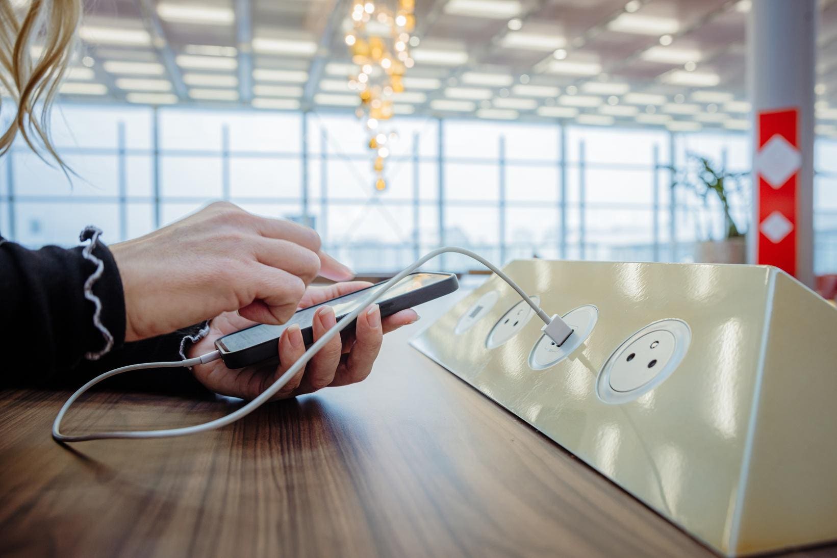 Personne rechargeant son téléphone à l'aéroport