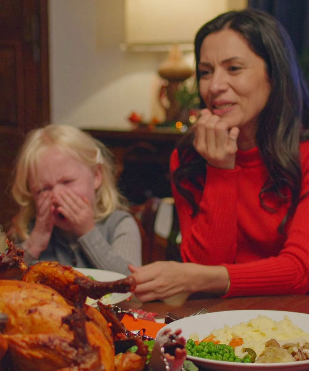 Jeune femme regardant une enfant qui ne mange pas