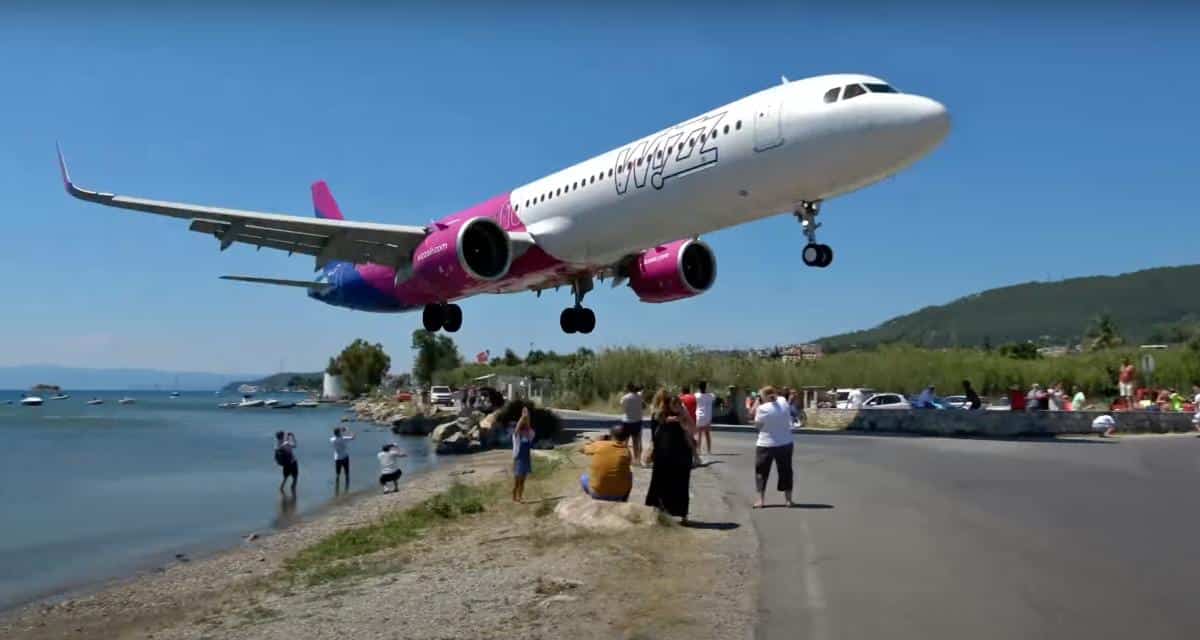Avion atterrissant à basse altitude près d'une plage bondée