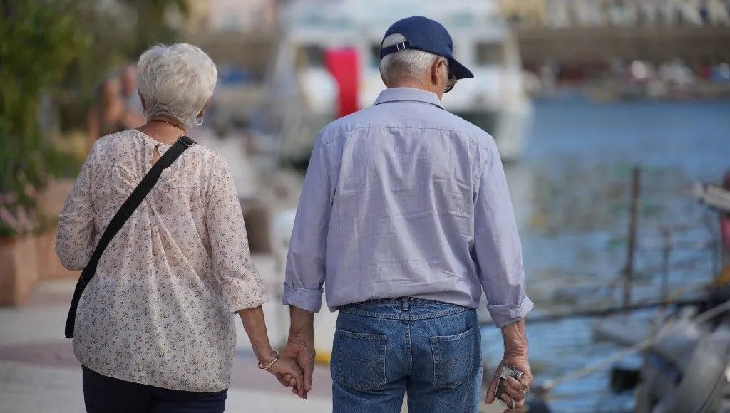 Couple marchant main dans la main dans un parc, image de complicité légère
