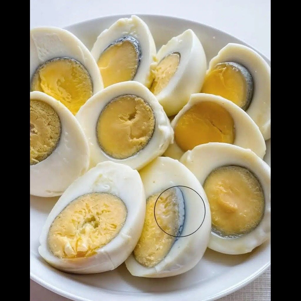Œuf dur coupé en deux montrant un anneau vert autour du jaune
