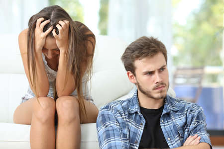 Couple en conflit assis sur un canapé