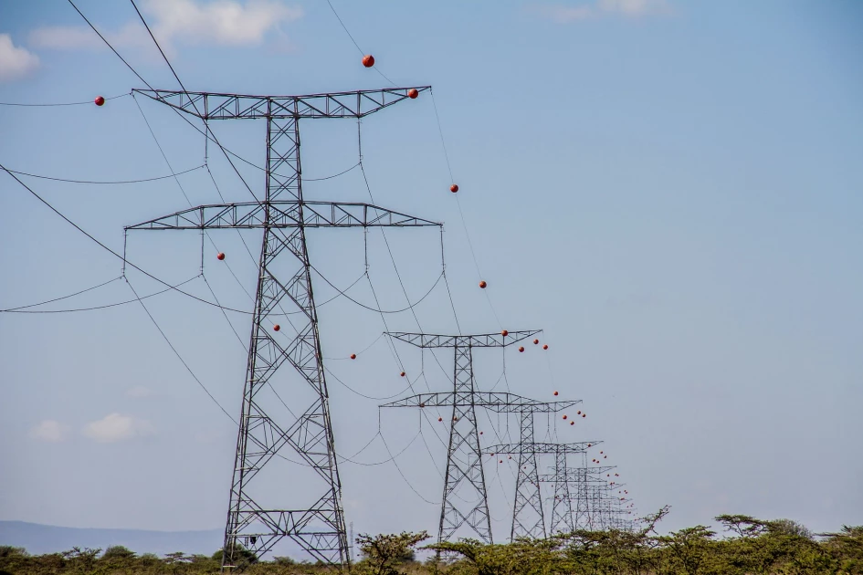 Gros plan sur des boules de balisage orange et blanches sur une ligne électrique