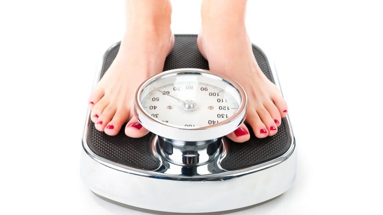 Femme souriante tenant une balance
