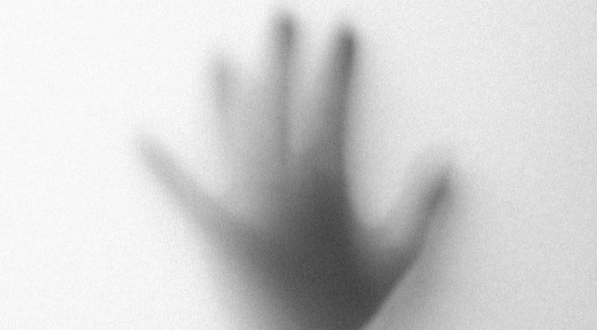 Main tendue vers la lumière en noir et blanc
