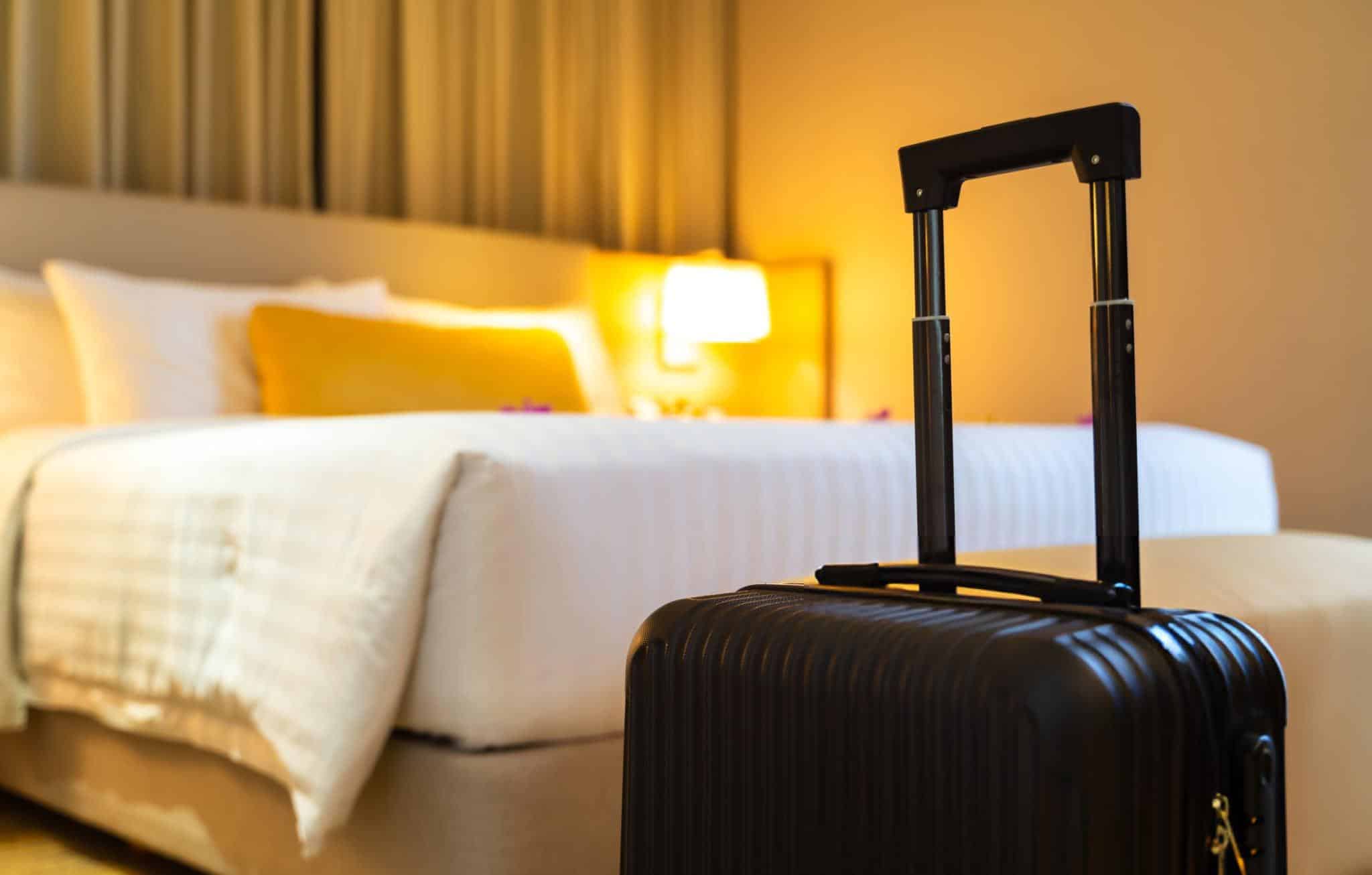 Valise posée sur un lit d'hôtel