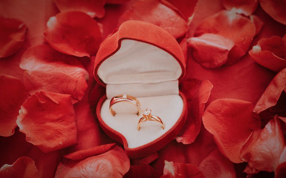 L'homme, désormais élégant, est à genoux et tend un écrin à la jeune femme, qui porte une main à sa bouche, émue.