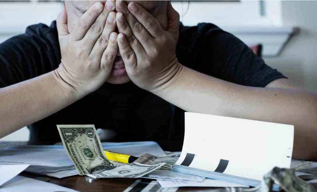 Une jeune femme tend de l'argent à une personne âgée, sous le regard d'autres clients