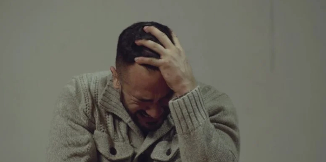 Cérémonie sur scène : un adolescent remet une médaille à son père sous les applaudissements