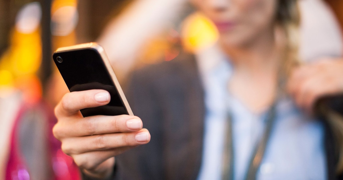 Un téléphone portable posé sur une table, écran allumé, symbolisant un appel crucial.