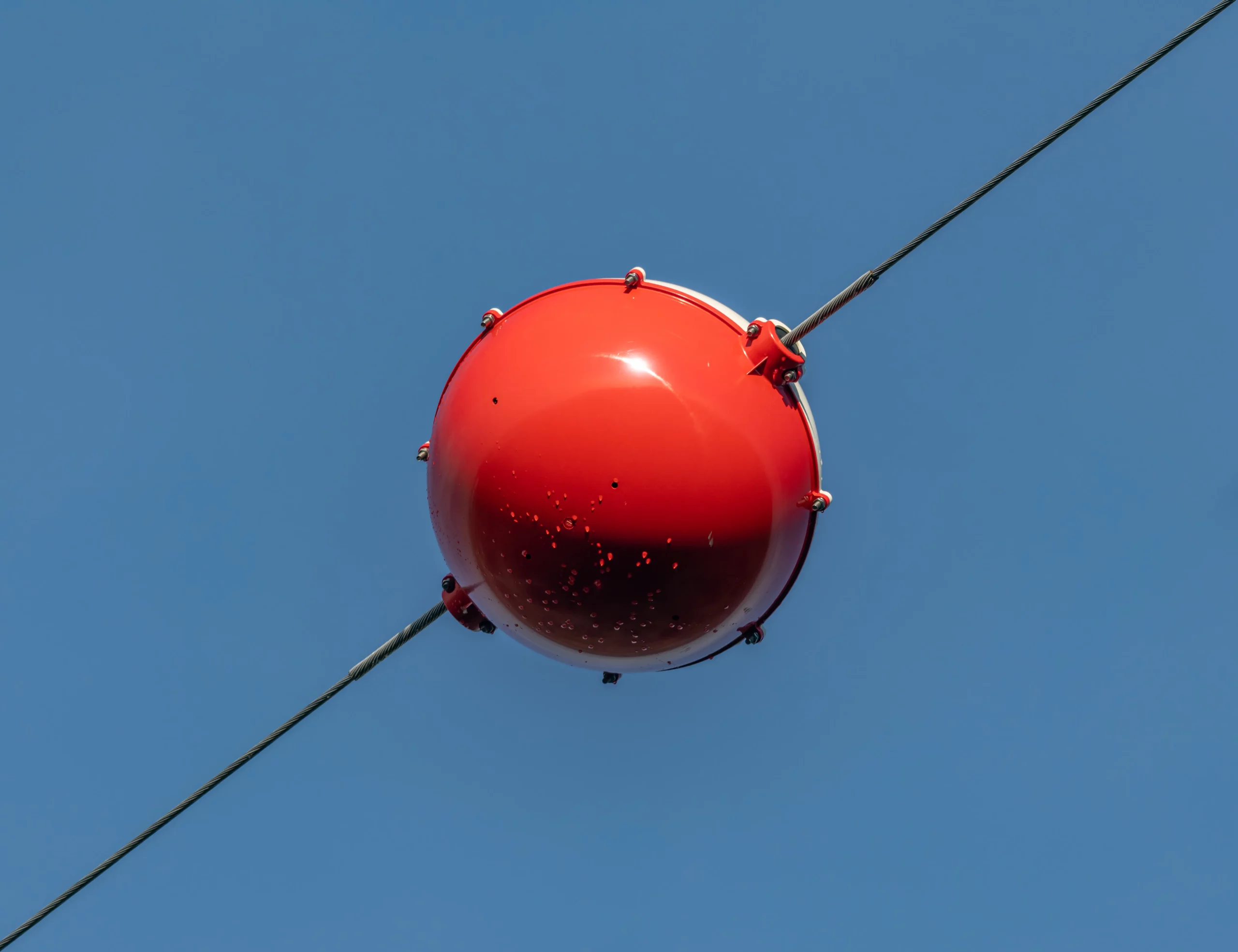 Vue rapprochée montrant la taille imposante des boules de balisage sur un câble