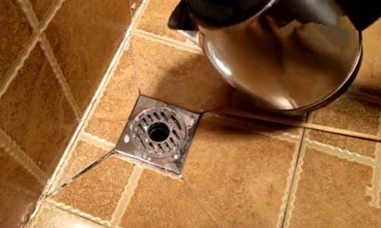 Personne versant de l'eau bouillante dans un évier