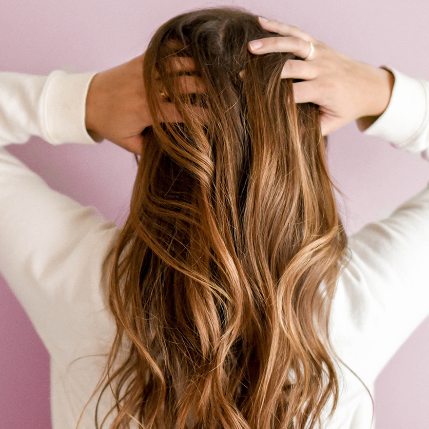 Femme aux cheveux brillants après rinçage au vinaigre de romarin