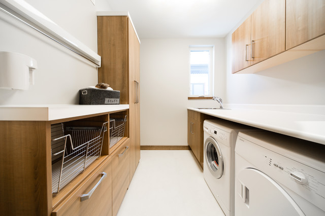 Buanderie spacieuse d'une maison bourgeoise avec une femme pliant du linge