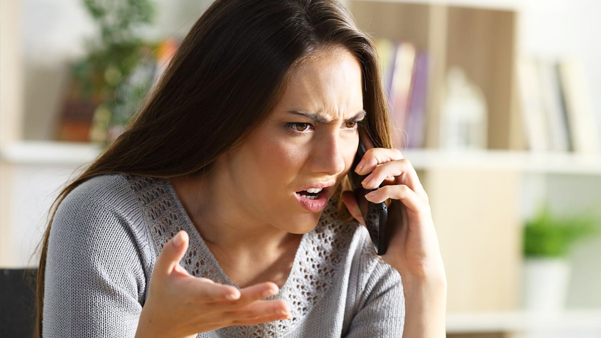 Femme souriante au téléphone, paraissant calme et maîtresse de la situation