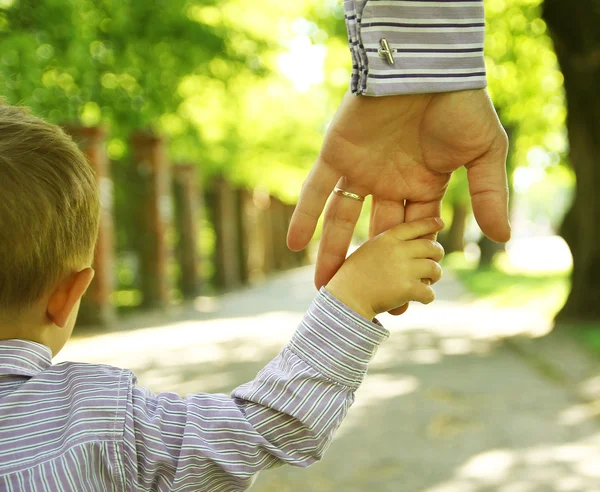 Parent tenant la main d'un enfant