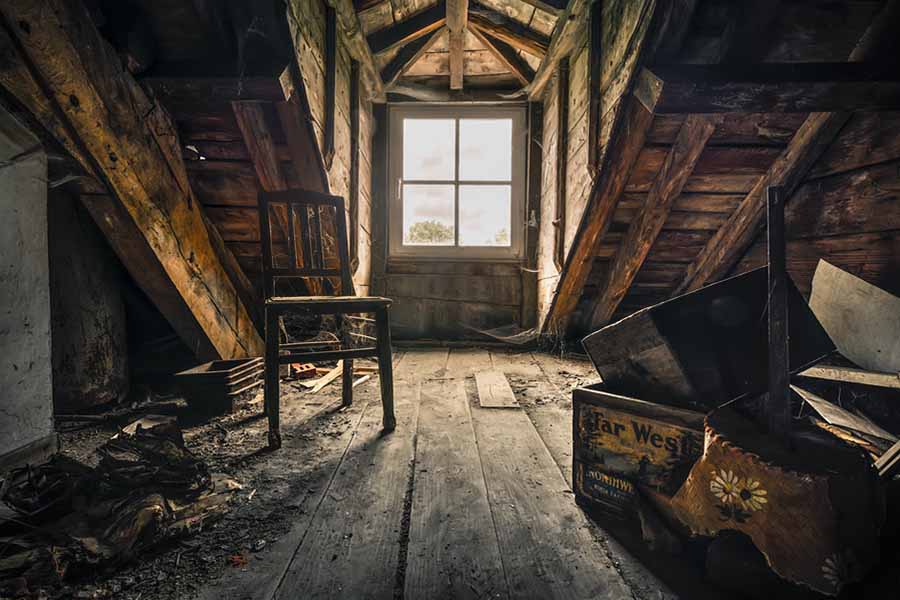 Intérieur d'un grenier ancien avec des objets empilés et de la poussière