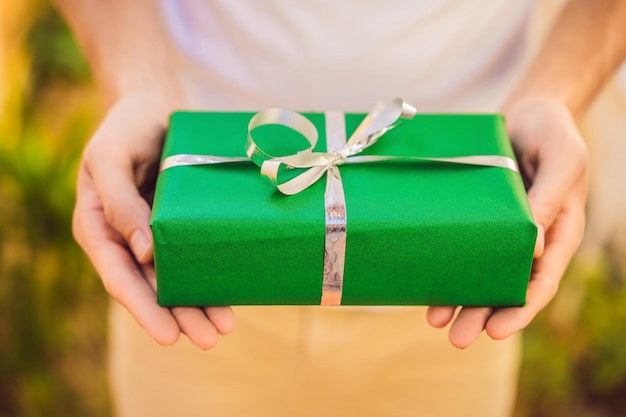 Homme souriant tenant un cadeau emballé