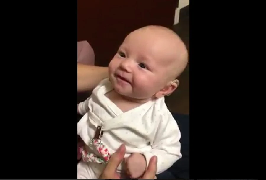 Sourire radieux de la petite fille sourde entendant sa maman