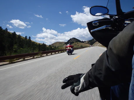 Motard effectuant le signe de la main sur sa moto