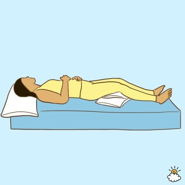 Femme sur le dos avec un oreiller sous les genoux pour soulager les douleurs menstruelles