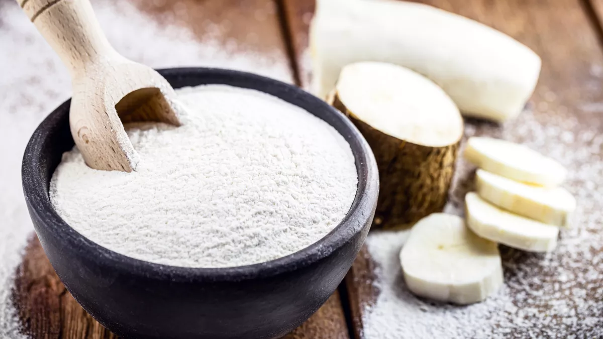 Ingrédient naturel en poudre, la farine de tapioca, à côté d'un lis de la paix