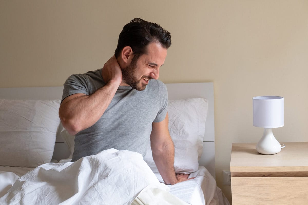 Personne se massant le cou au réveil