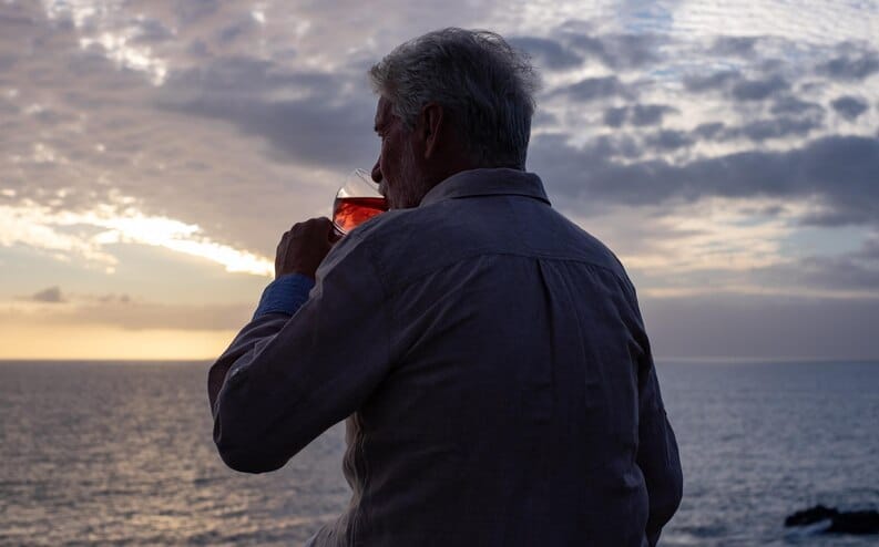 Homme mûr contemplant le coucher de soleil