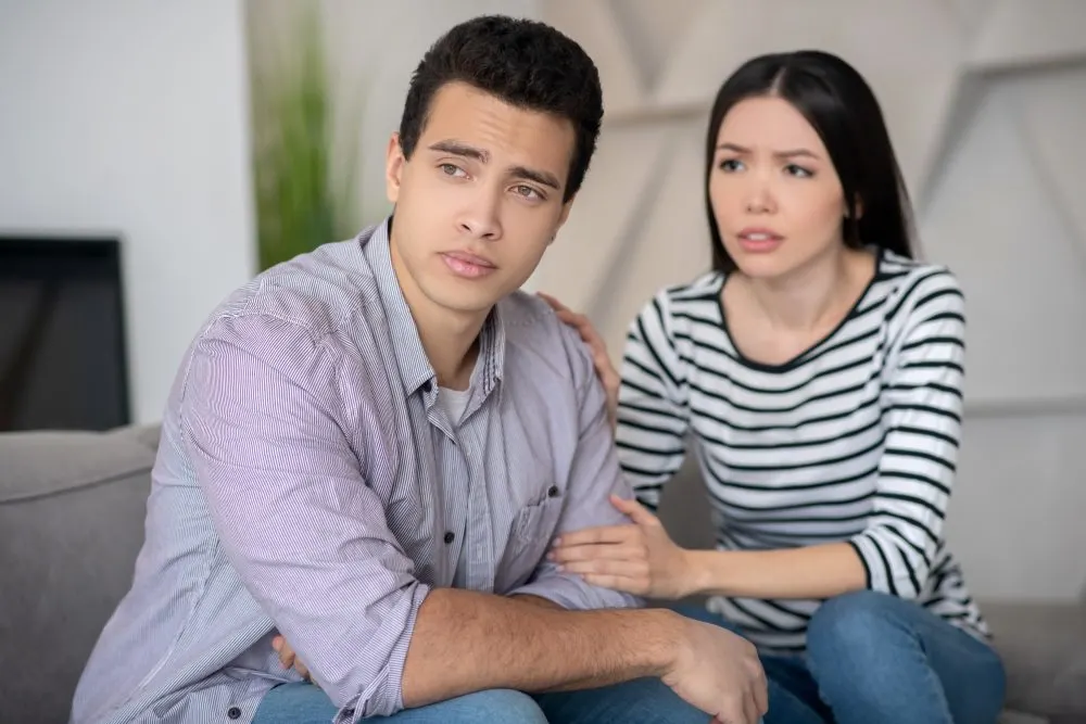 Femme réconfortant un homme qui semble perdu dans ses pensées